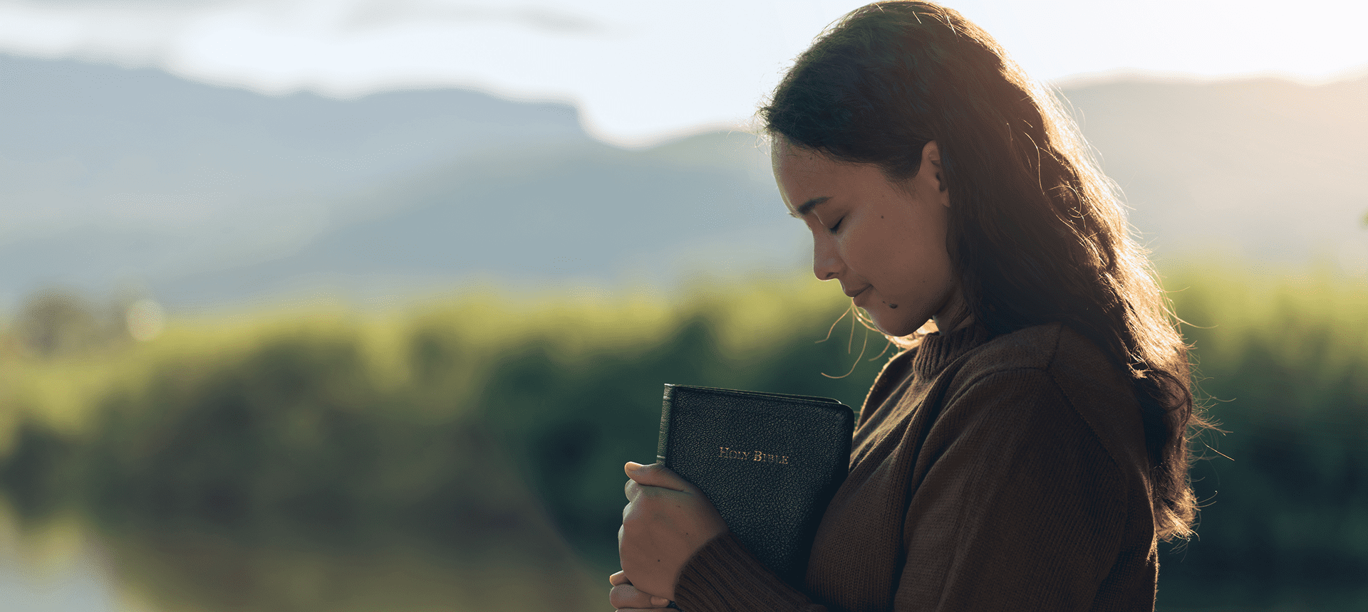 Woman holding a Bible outdoors